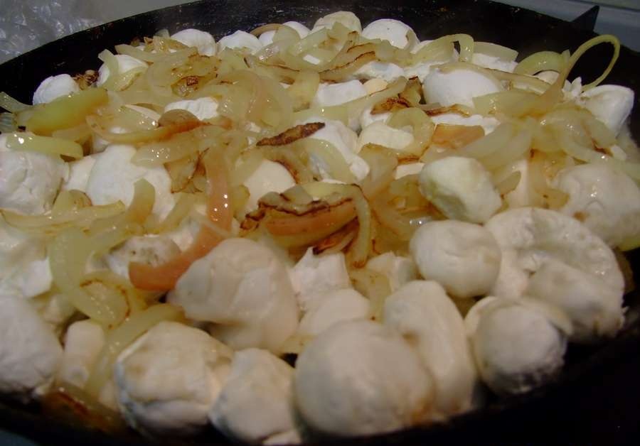 сложенные грибы дождевики в сковороде с измельченным луком