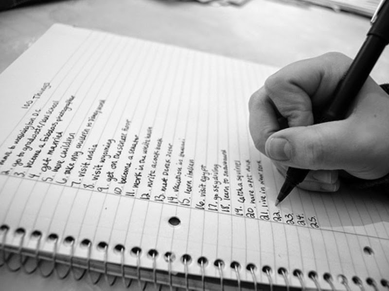 девушка составляет список желаний, чтобы выбрать вновогоднюю или рождественскую ночь